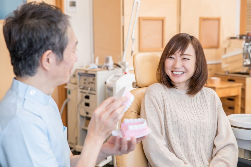 歯科医師と女性患者が笑顔で会話している写真