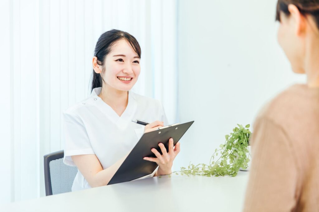 歯科医院でカウンセリングを受ける女性とスタッフの笑顔