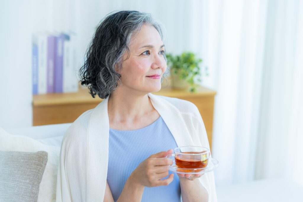 更年期で口の乾きに悩む女性がリラックスして水分補給をする様子