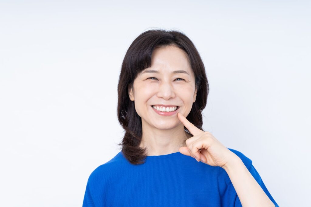 50代女性が白い歯を見せて笑う様子