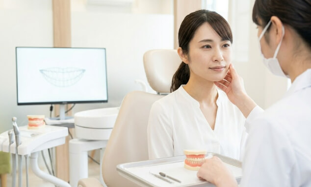 歯科医師から治療の説明を受ける女性患者
