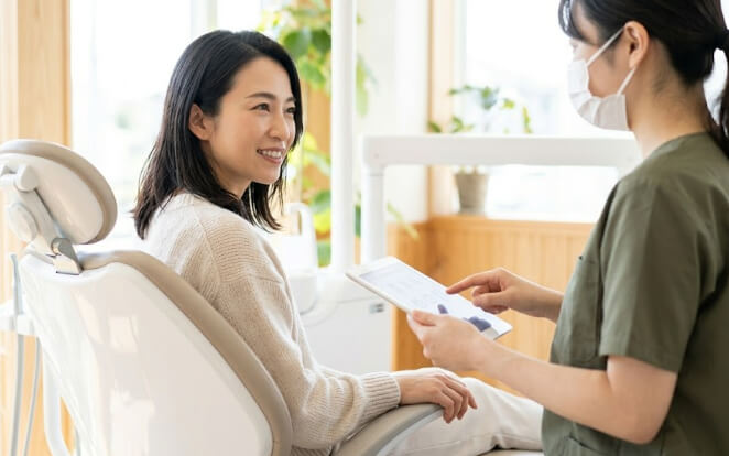 歯科衛生士から治療内容の説明を受ける日本人女性