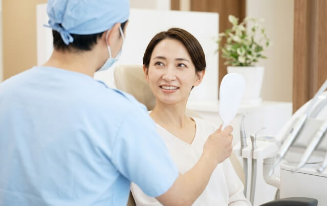 歯科医院の明るい診察台で、安心した笑顔でリラックスする日本人女性