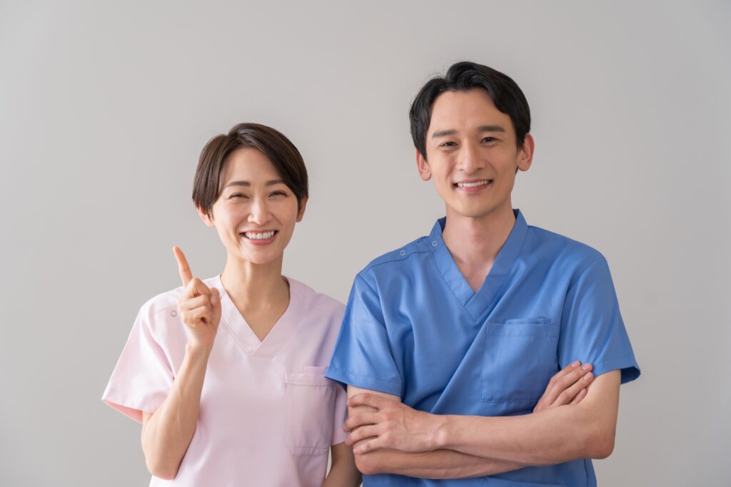歯科医院の男性・女性スタッフが笑顔で並んでいる様子。