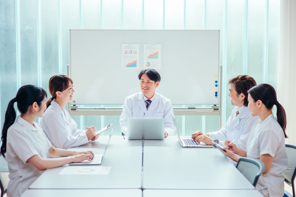 歯科の専門スタッフが院内で話し合いをしている様子。連携やチーム医療体制を示すイメージに最適。