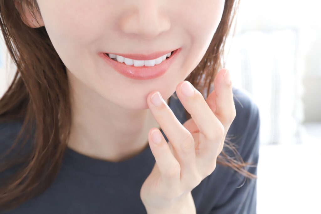 笑顔の女性の口元のアップ写真。白く健康的な歯が見える。