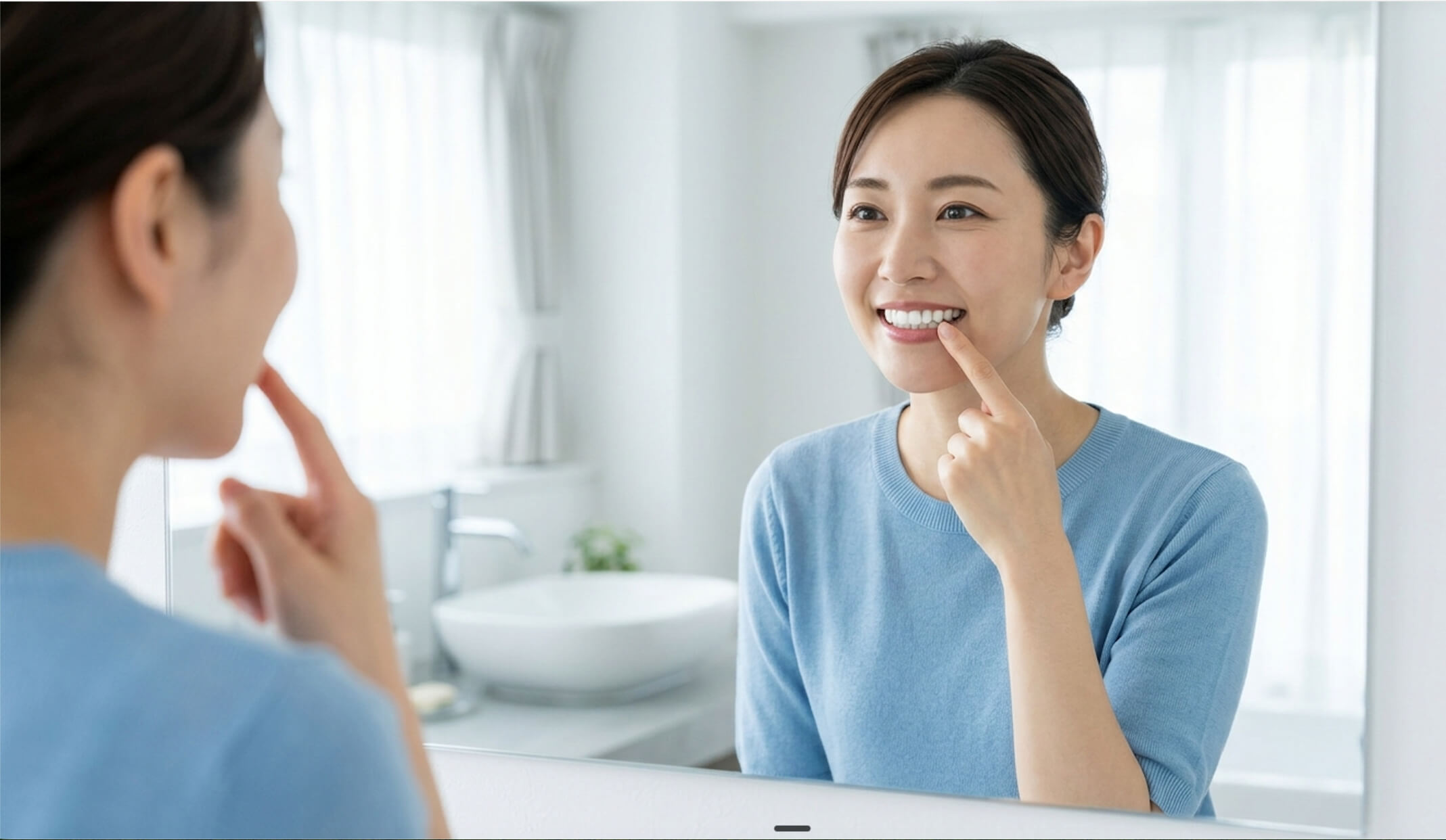 鏡で前歯の黄ばみを気にする日本人女性の様子