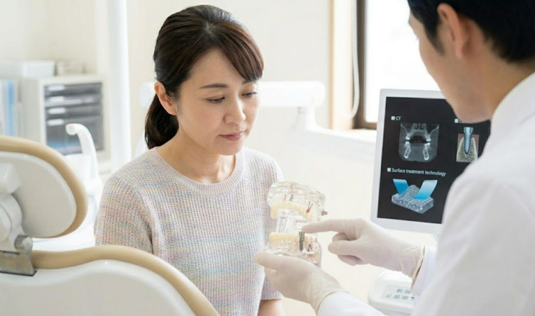歯科医師の説明を聞き、インプラントの技術に納得する日本人女性の様子