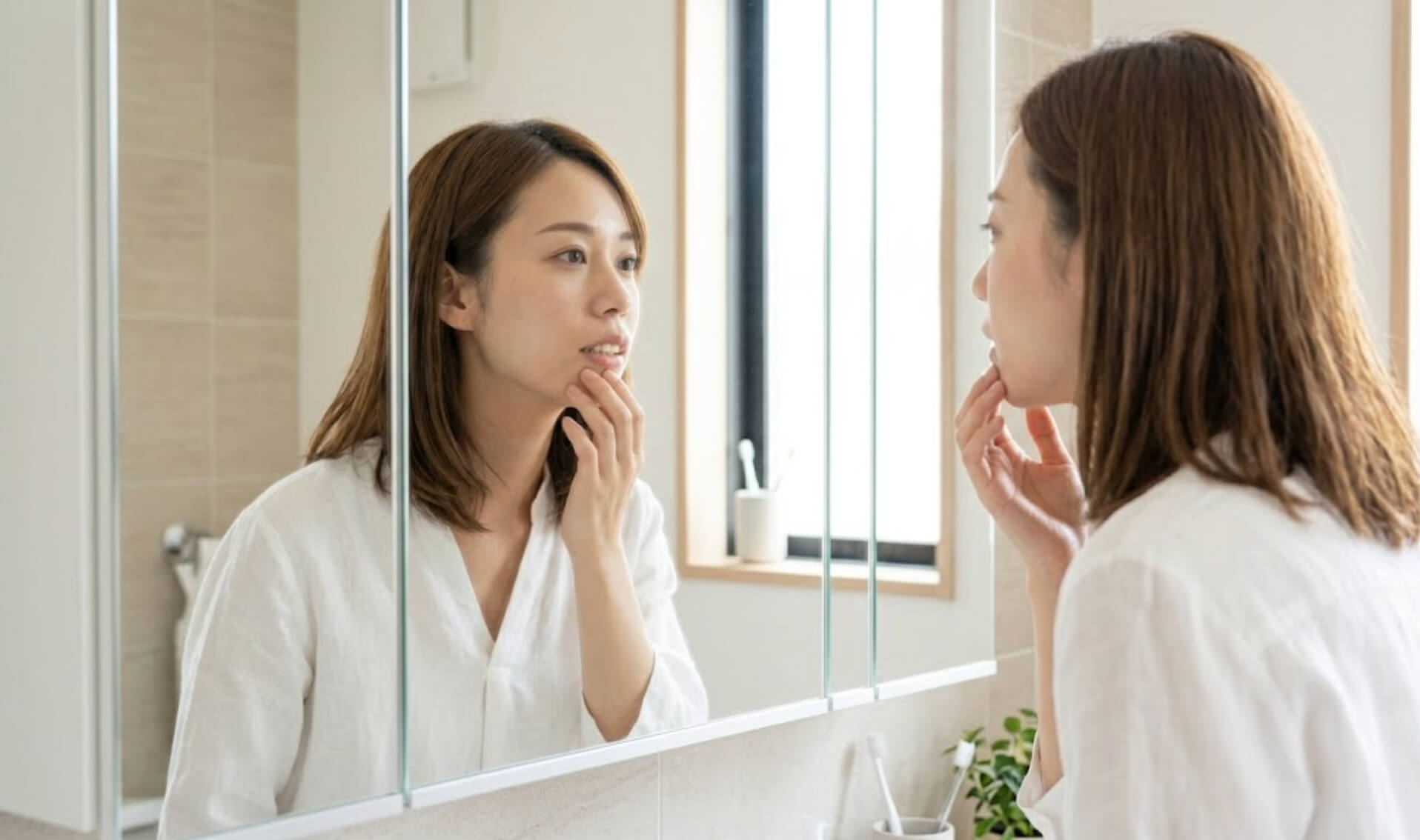 自分の出っ歯の症状について、鏡を見てセルフチェックする日本人女性の様子