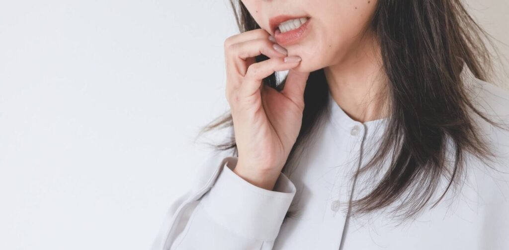 歯周病の痛みを感じている中年女性の写真