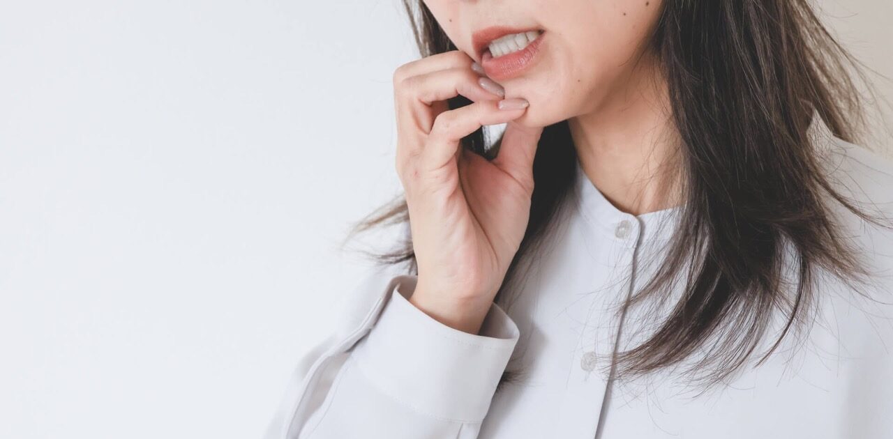 歯周病の痛みを感じている中年女性の写真