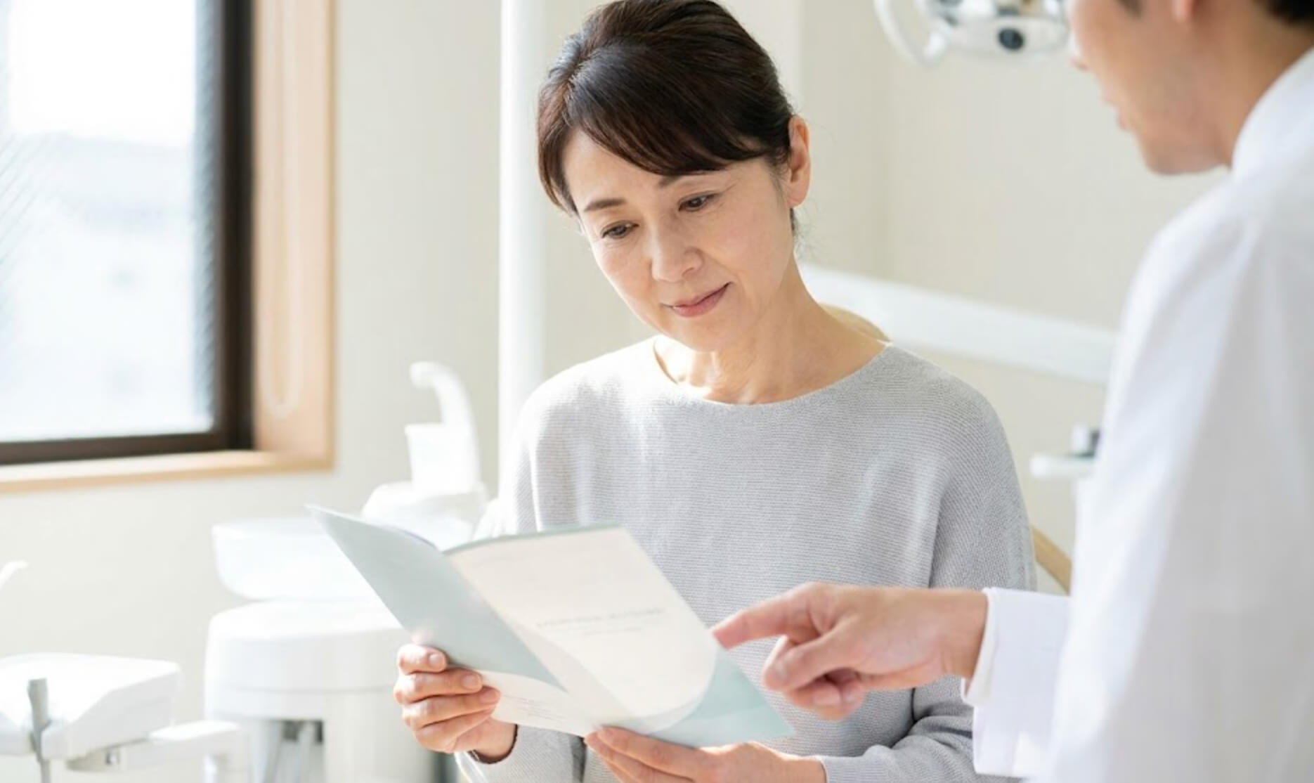 ストローマンインプラントのパンフレットを真剣に見る日本人女性の様子